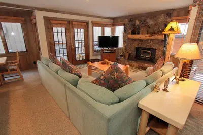a living room with a large couch and a fireplace at Mountainback 48 Corner Unit in Mammoth Lakes