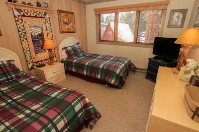 a bedroom with two beds and a television at Mountainback 48 Corner Unit in Mammoth Lakes