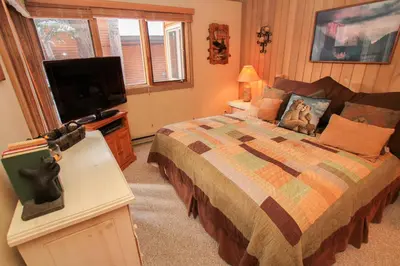 a bedroom with a bed and a flat screen tv at Mountainback 48 Corner Unit in Mammoth Lakes