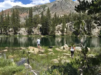 two people standing on the shore of a lake at Mountainback 45 Den in Mammoth Lakes