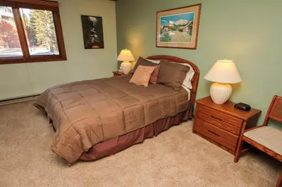 a bedroom with a bed and two lamps and a chair at Mountainback 37 Den in Mammoth Lakes