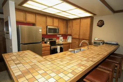 a kitchen with a counter with a sink and a refrigerator at Mountainback 37 Den in Mammoth Lakes