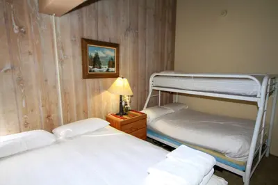 two bunk beds in a room with a lamp at Mammoth Ski Racquet Club 64 - Pet Friendly in Mammoth Lakes