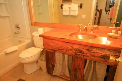 a bathroom with a sink and a toilet and a mirror at Mammoth Ski Racquet Club 64 - Pet Friendly in Mammoth Lakes