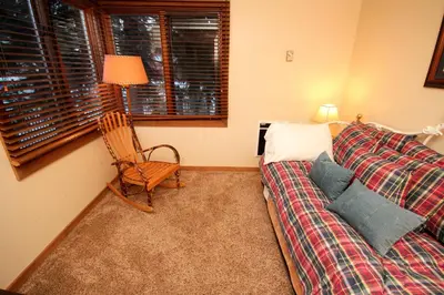 a bedroom with a couch and a chair and a window at Mountainback 49 Den in Mammoth Lakes
