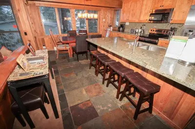 a kitchen with a bar with stools and a counter at Mountainback 52 Loft Corner in Mammoth Lakes