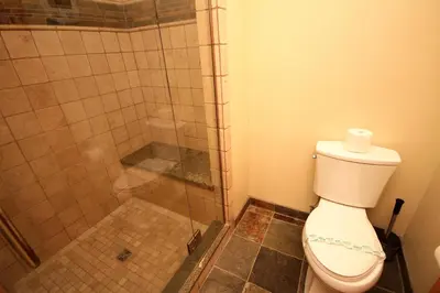 a bathroom with a toilet and a glass shower at Mountainback 52 Loft Corner in Mammoth Lakes