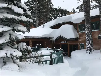 a log cabin with snow on the roof at Mountainback 52 Loft Corner in Mammoth Lakes