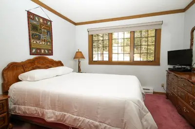 a bedroom with a white bed and a television at Mountainback #74 in Mammoth Lakes