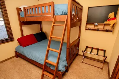 a bedroom with two bunk beds and a television at Mountainback 73 Den in Mammoth Lakes