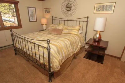 a bedroom with a bed and a table with a lamp at Mountainback 73 Den in Mammoth Lakes
