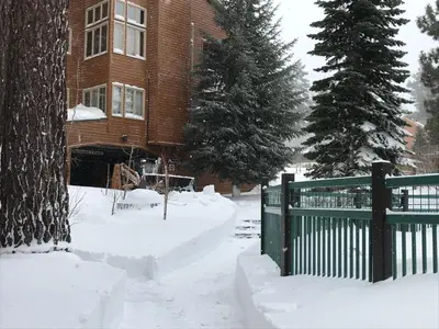 a house with a green fence in the snow at Mountainback #71 in Mammoth Lakes