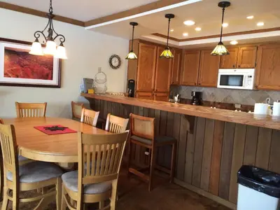 a kitchen with a wooden table and a kitchen counter at Mountainback #71 in Mammoth Lakes