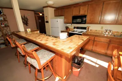 a kitchen with a large wooden table and chairs at Mountainback 60 Corner Unit in Mammoth Lakes