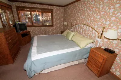 a bedroom with a bed and a tv in it at Mountainback 60 Corner Unit in Mammoth Lakes