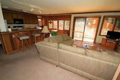a living room with a couch and a kitchen at Mountainback 60 Corner Unit in Mammoth Lakes