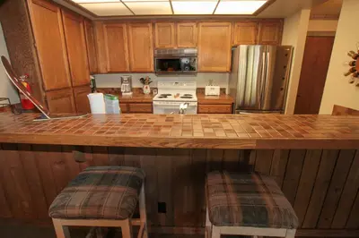 a kitchen with a large counter with stools in it at Mountainback 12 2 Bdrm 3 Ba Loft - Pet Ok in Mammoth Lakes