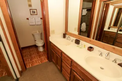 a bathroom with a sink and a toilet and a mirror at Mountainback 12 2 Bdrm 3 Ba Loft - Pet Ok in Mammoth Lakes