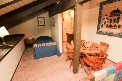 a bedroom with a table and a bed in a room at Discovery 4 #128, Loft in Mammoth Lakes