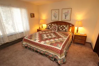 a bedroom with a bed and two lamps and a window at Discovery 4 #128, Loft in Mammoth Lakes