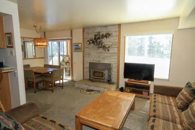 a living room with a couch and a television and a table at Discovery 4 125 in Mammoth Lakes