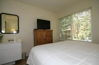 a bedroom with a bed and a mirror and a television at Discovery 4 117 in Mammoth Lakes