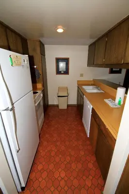 a kitchen with a white refrigerator and wooden cabinets at Discovery 4 #135 in Mammoth Lakes