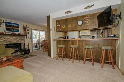 a living room with a kitchen and bar with stools at Discovery 4 137 in Mammoth Lakes