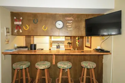 a kitchen with a bar with stools and a clock at Discovery 4 137 in Mammoth Lakes
