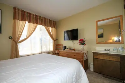 a bedroom with a bed and a sink and a mirror at Discovery 4 137 in Mammoth Lakes