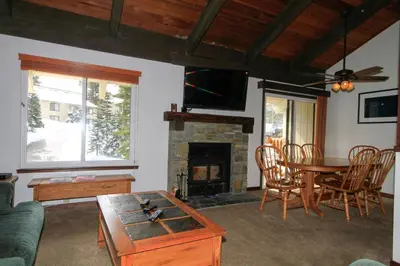 a living room with a table and a fireplace at Discovery 4 152 Loft Pet Ok in Mammoth Lakes
