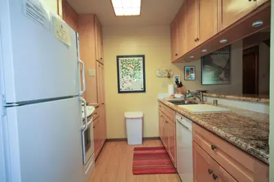 a kitchen with a white refrigerator and wooden cabinets at Discovery 4 142 Loft in Mammoth Lakes