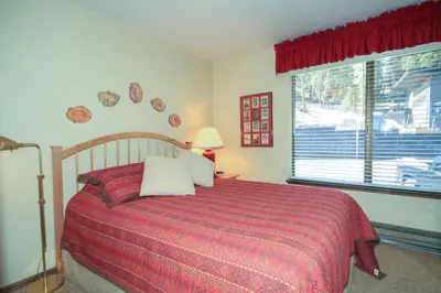 a bedroom with a bed with a red blanket and a window at Discovery 4 142 Loft in Mammoth Lakes