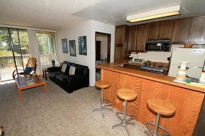a kitchen with a bar and a living room with a couch at Crestview 17 in Mammoth Lakes