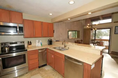 a kitchen with wooden cabinets and stainless steel appliances at Mammoth Ski Racquet Club 86 - Pet Friendly in Mammoth Lakes