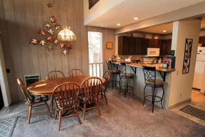 a dining room with a table and chairs and a kitchen at Mammoth Ski & Racquet Club #84 in Mammoth Lakes