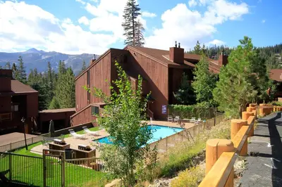 a building with a swimming pool in front of it at Mammoth Ski Racquet Club 67 in Mammoth Lakes