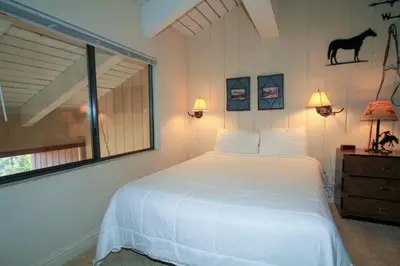a bedroom with a white bed and a horse on the wall at Mammoth Ski Racquet Club 67 in Mammoth Lakes