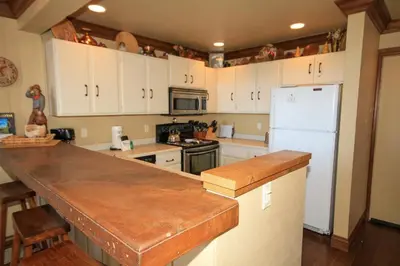 a kitchen with white cabinets and a white refrigerator at Mammoth Ski Racquet Club 67 in Mammoth Lakes