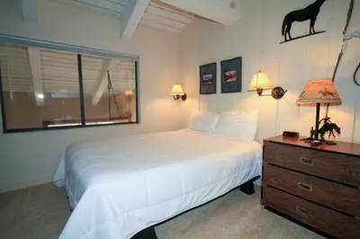 a bedroom with a bed and a dresser and a window at Mammoth Ski Racquet Club 67 in Mammoth Lakes