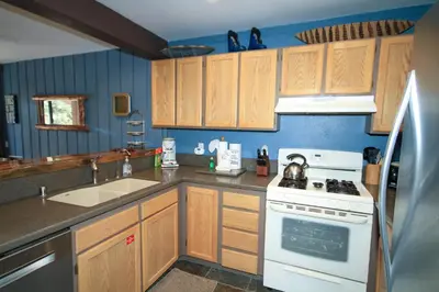 a kitchen with wooden cabinets and a white stove top oven at Mammoth Ski Racquet Club 94 2 bedroom Dog Friendly in Mammoth Lakes