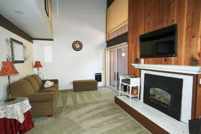 a living room with a fireplace with a flat screen tv at Mammoth Ski Racquet Club 120 - Pet Friendly in Mammoth Lakes