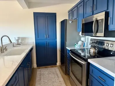 a kitchen with blue cabinets and a blue door at Mammoth Ski Racquet Club 62 - Newly Renovated 2025 in Mammoth Lakes
