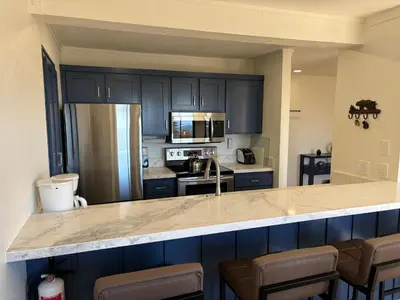 a kitchen with dark blue cabinets and a counter top at Mammoth Ski Racquet Club 62 - Newly Renovated 2025 in Mammoth Lakes