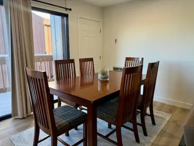 a wooden dining room table with chairs and a window at Mammoth Ski Racquet Club 62 - Newly Renovated 2025 in Mammoth Lakes