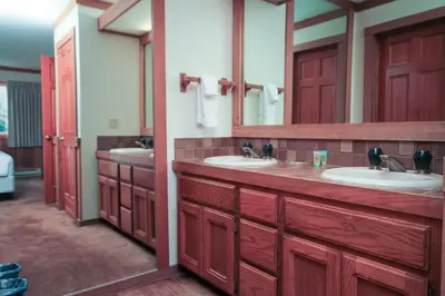 a bathroom with two sinks and two mirrors at Mountainback 112 Corner Unit in Mammoth Lakes