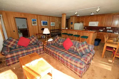a living room with two couches and a kitchen at Mountainback 112 Corner Unit in Mammoth Lakes