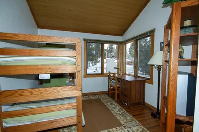 a bedroom with bunk beds and a desk in a cabin at Mountainback 105 Loft Den in Mammoth Lakes