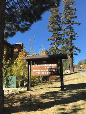 a sign in front of a building with a tree at Mountainback 97 Loft in Mammoth Lakes
