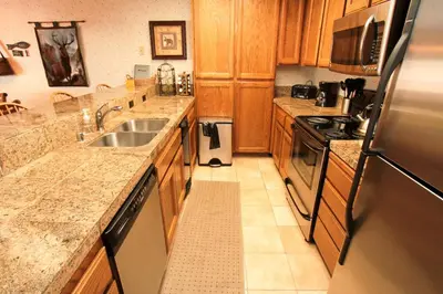 a kitchen with wooden cabinets and a stainless steel refrigerator at Mountainback 94 in Mammoth Lakes